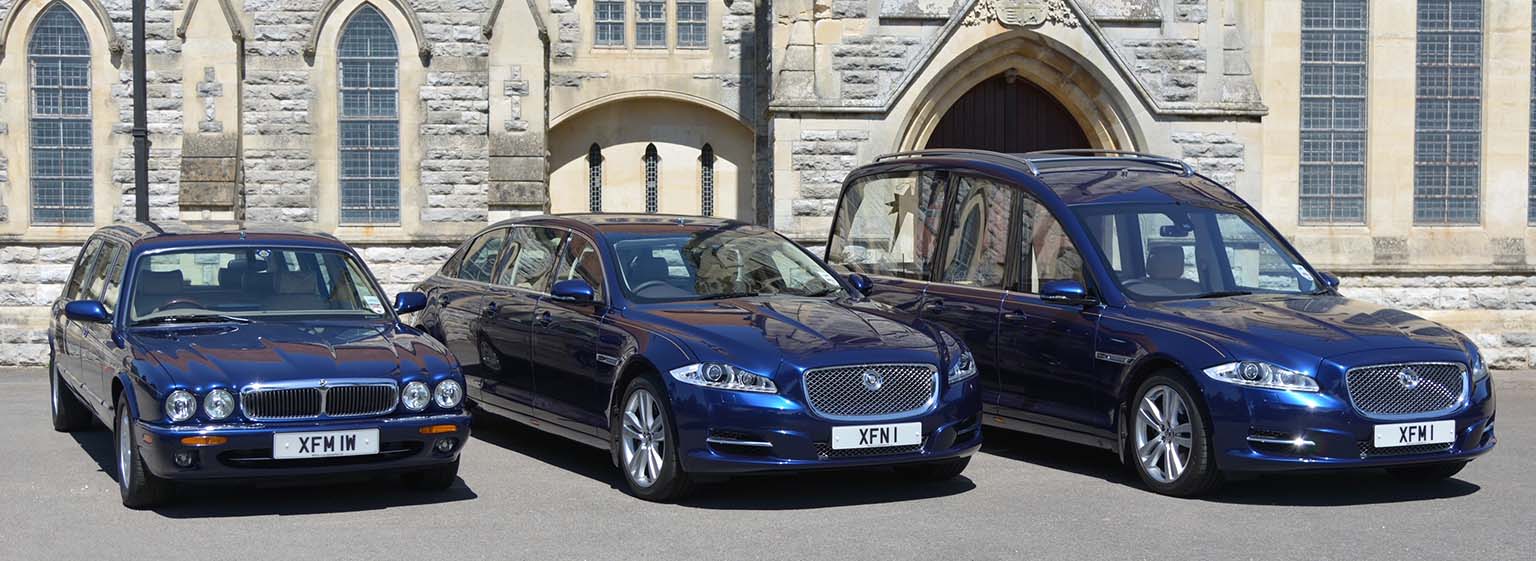 Harry Tomes Pacific Blue Jaguar hearse and limousines parked outside a stone church